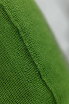 Detailaufnahme der Naht eines Strick-Dekokissens in der Farbe Grün mit sichtbarer Struktur des Strickmaterials.