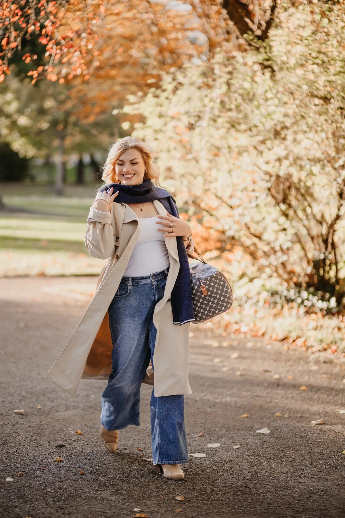 Frau trägt Strickschal in Navyblau-Melange beim Spaziergang im Park.
