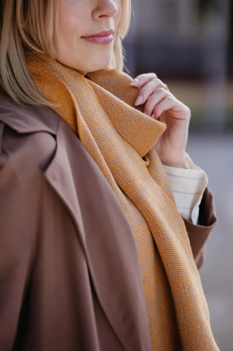 Detailaufnahme des Strickschals in Curry-Melange mit feiner Strick-Struktur.