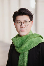 Strickschal in Grün-Melange getragen von Mann im Porträt.