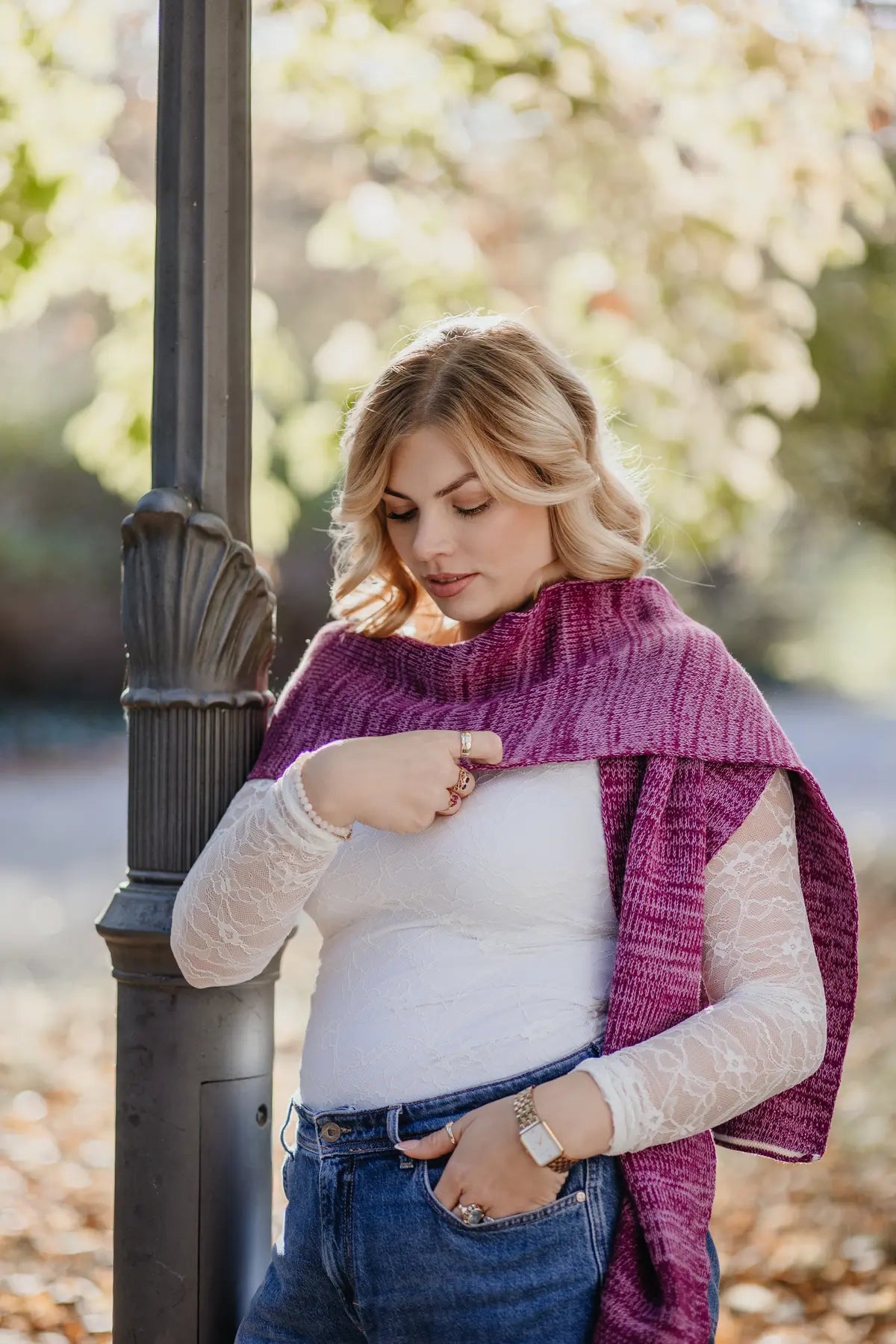 Strickschal in Beerenfarben-Melange getragen von Frau im herbstlichen Außenbereich.