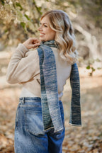 Frau trägt Petrol melierten Strickschal kombiniert mit Strickpullover im Outdoor-Bereich.