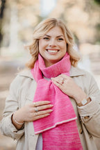 Strickschal in Rosa-Melange als Outfit kombiniert mit beigem Mantel.