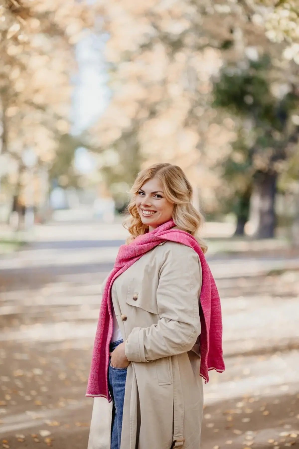 Frau trägt Strickschal in Rosa-Melange in seitlicher Ansicht.