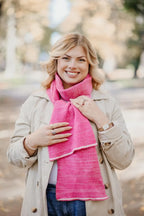 Strickschal in Rosa-Melange getragen von Frau im Außenbereich.